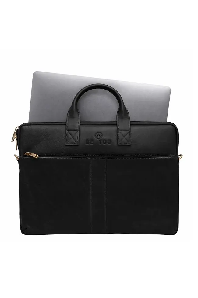 Black full-grain leather laptop bag showing padded interior compartment with laptop inside