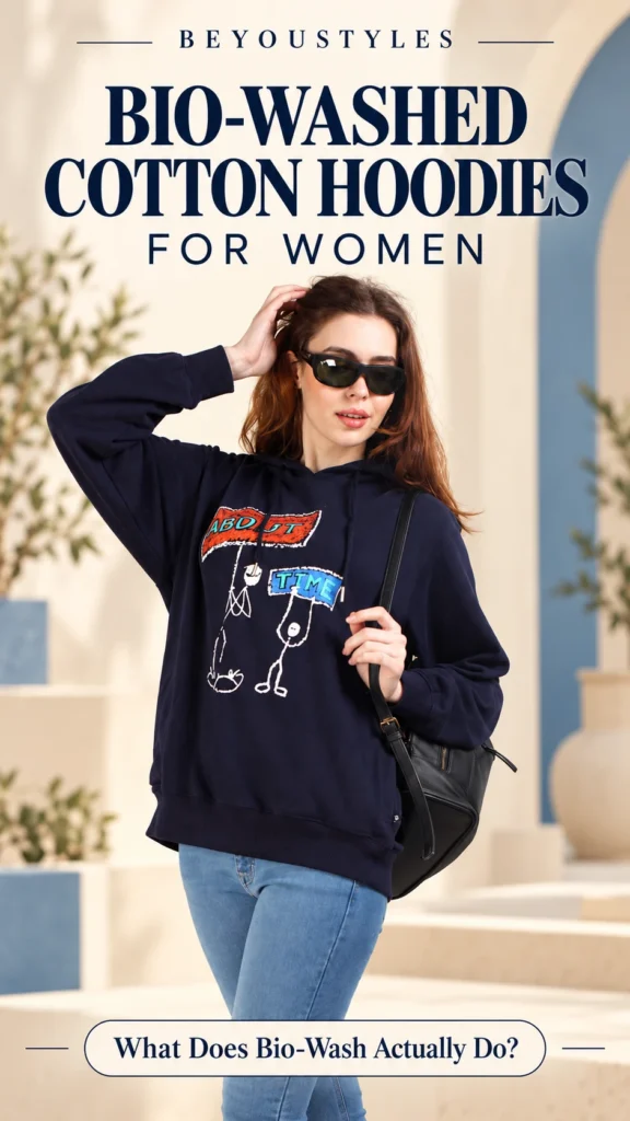 Woman wearing a navy graphic cotton hoodie in a Beyoustyles thumbnail about bio-washed cotton hoodies for women.